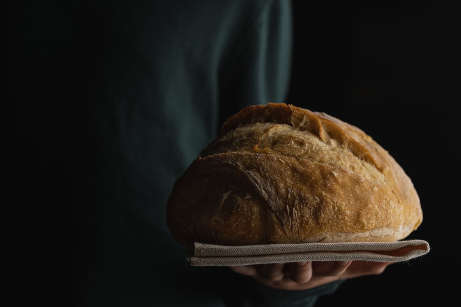 Frisch gebackener Brotlaib in Händen